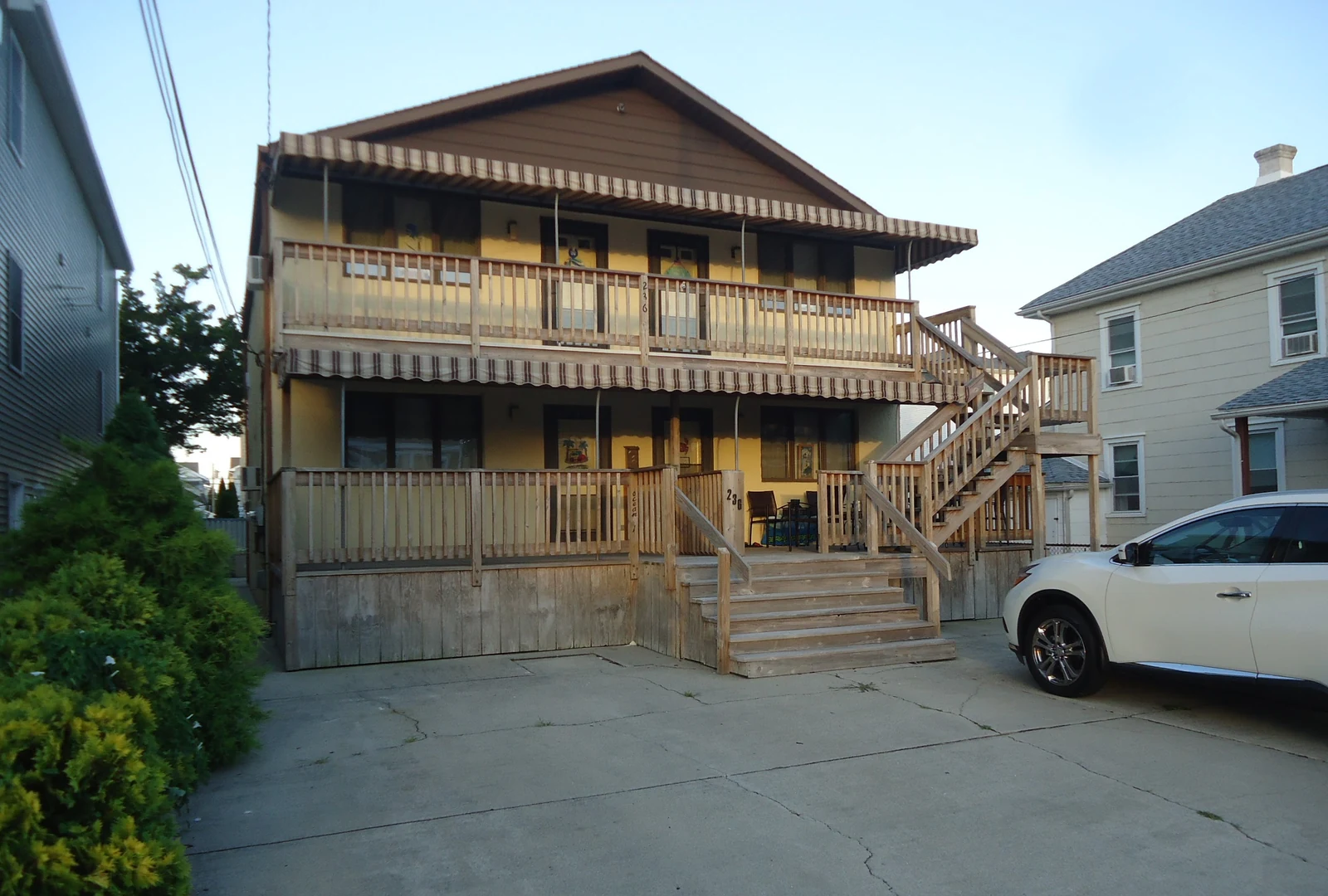 Two-story house in Wildwood, New Jersey, with a separate porch on each floor and an outside wooden staircase leading to the upper level