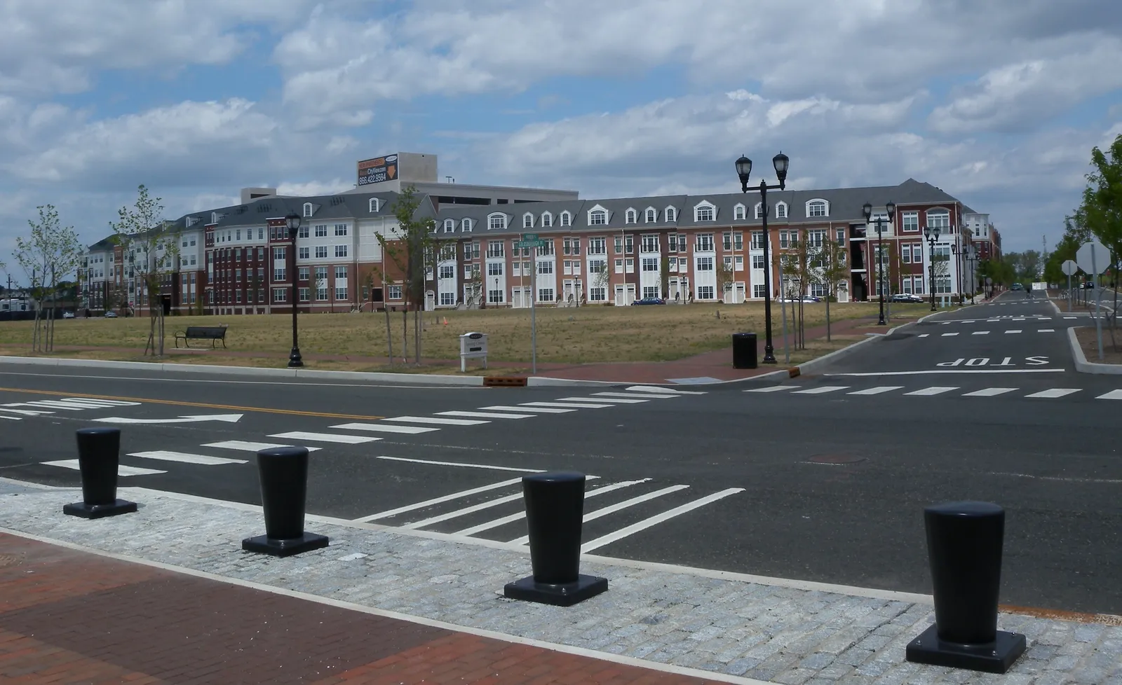 Rows of new three- and four-story brick apartment buildings across a wide street at The Peninsula in Bayonne, Hudson County