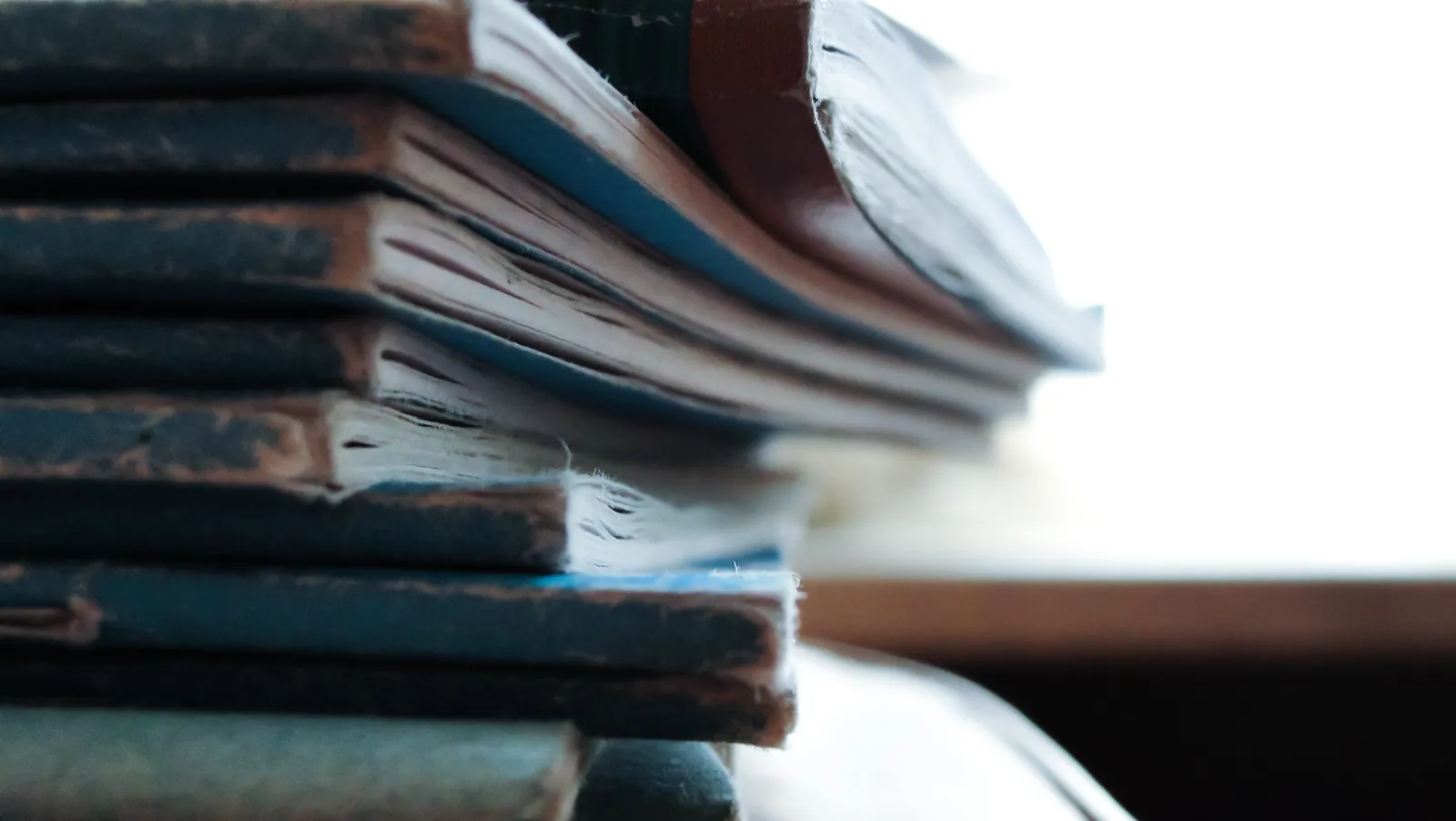 A tall stack of worn paper folders and notebooks, the kind of paperwork a mortgage file is built from