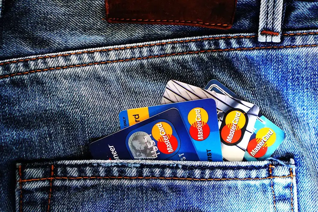 A fan of credit cards held in one hand, the balances that a debt consolidation refinance pays off